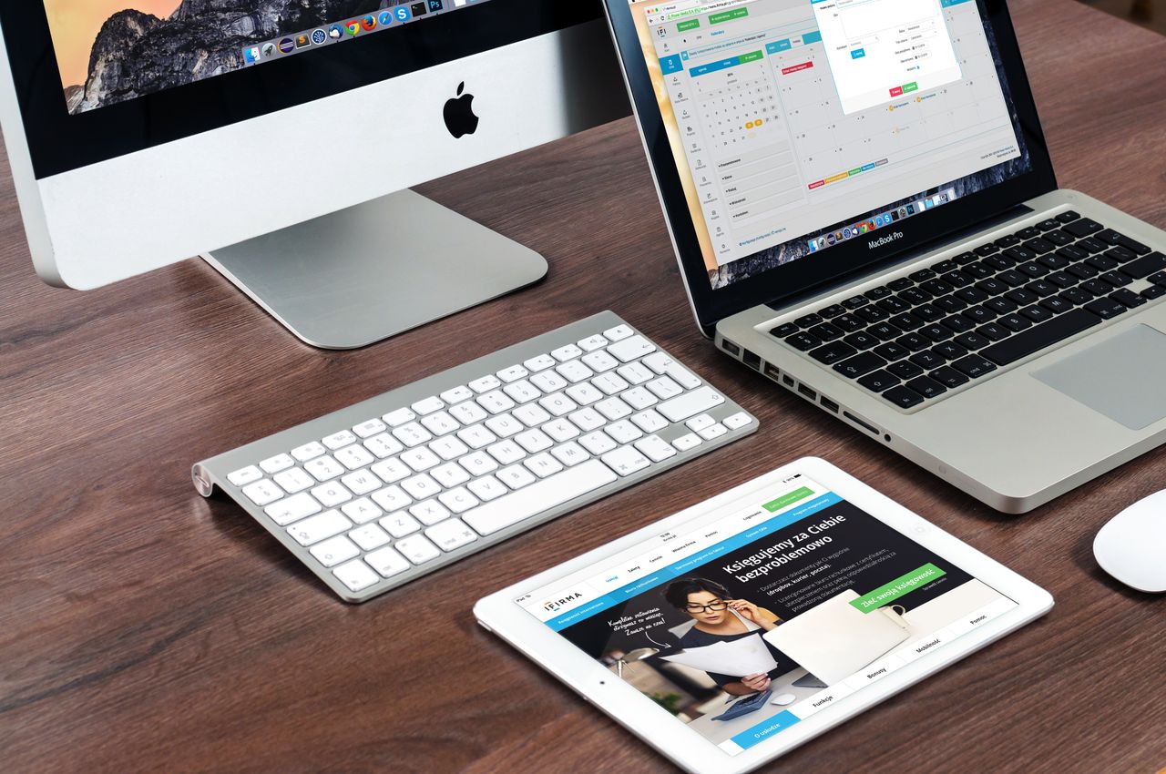 Una raffinata postazione da ufficio con dispositivi Apple: iMac, MacBook e iPad.